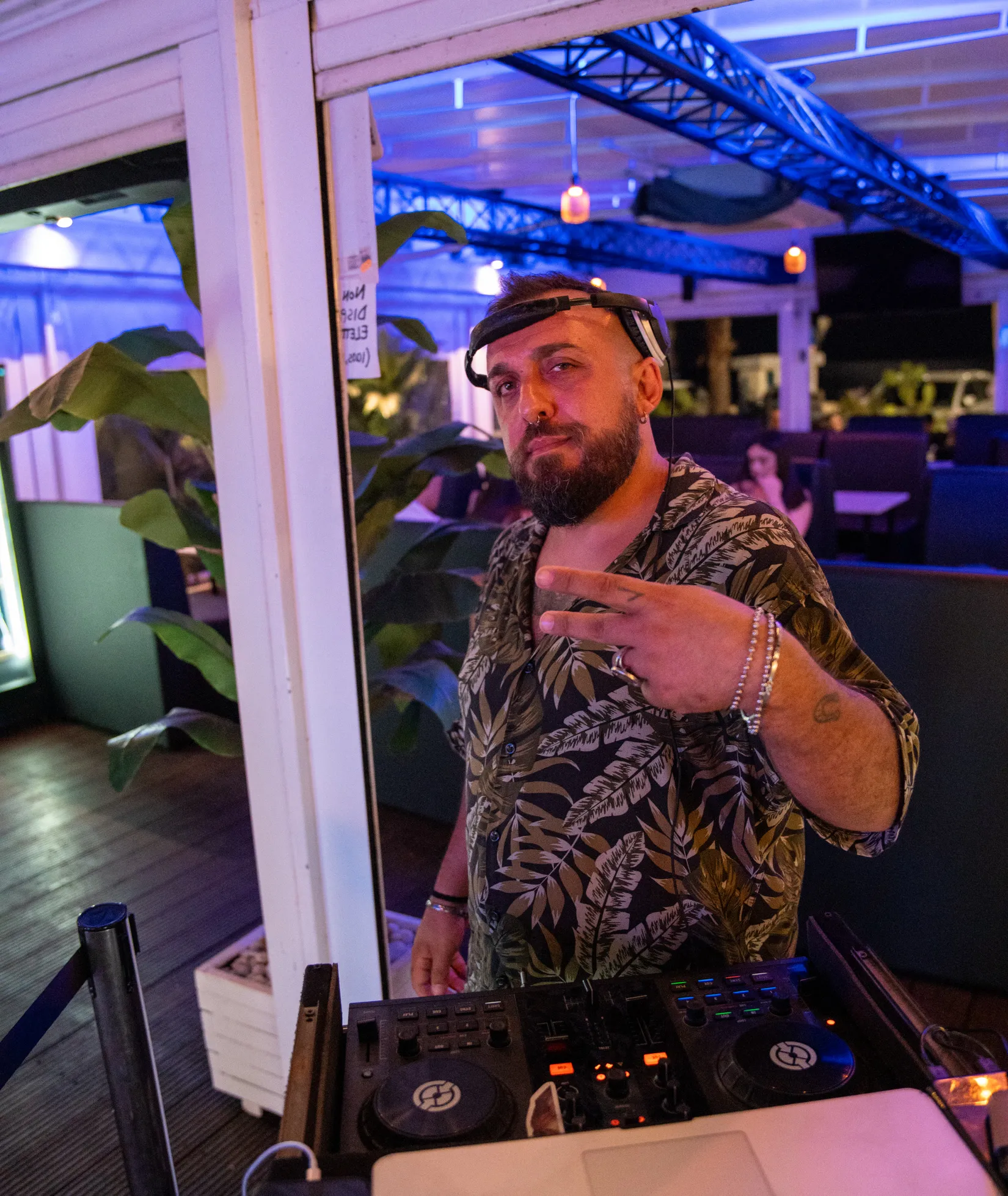 Il DJ alla console, col locale illuminato dietro